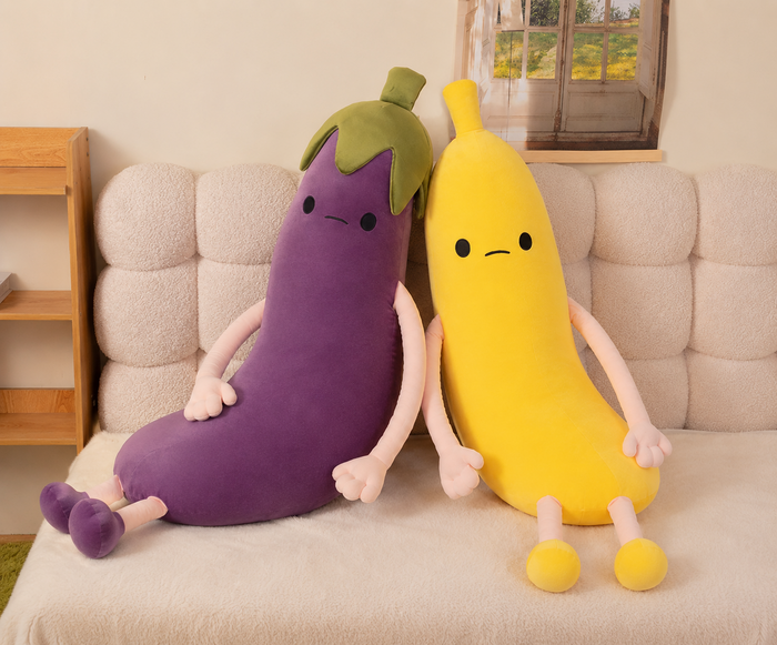 Banana and eggplant plush pillows on sofa
