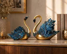 Gold and blue swan figurines styled on a console table